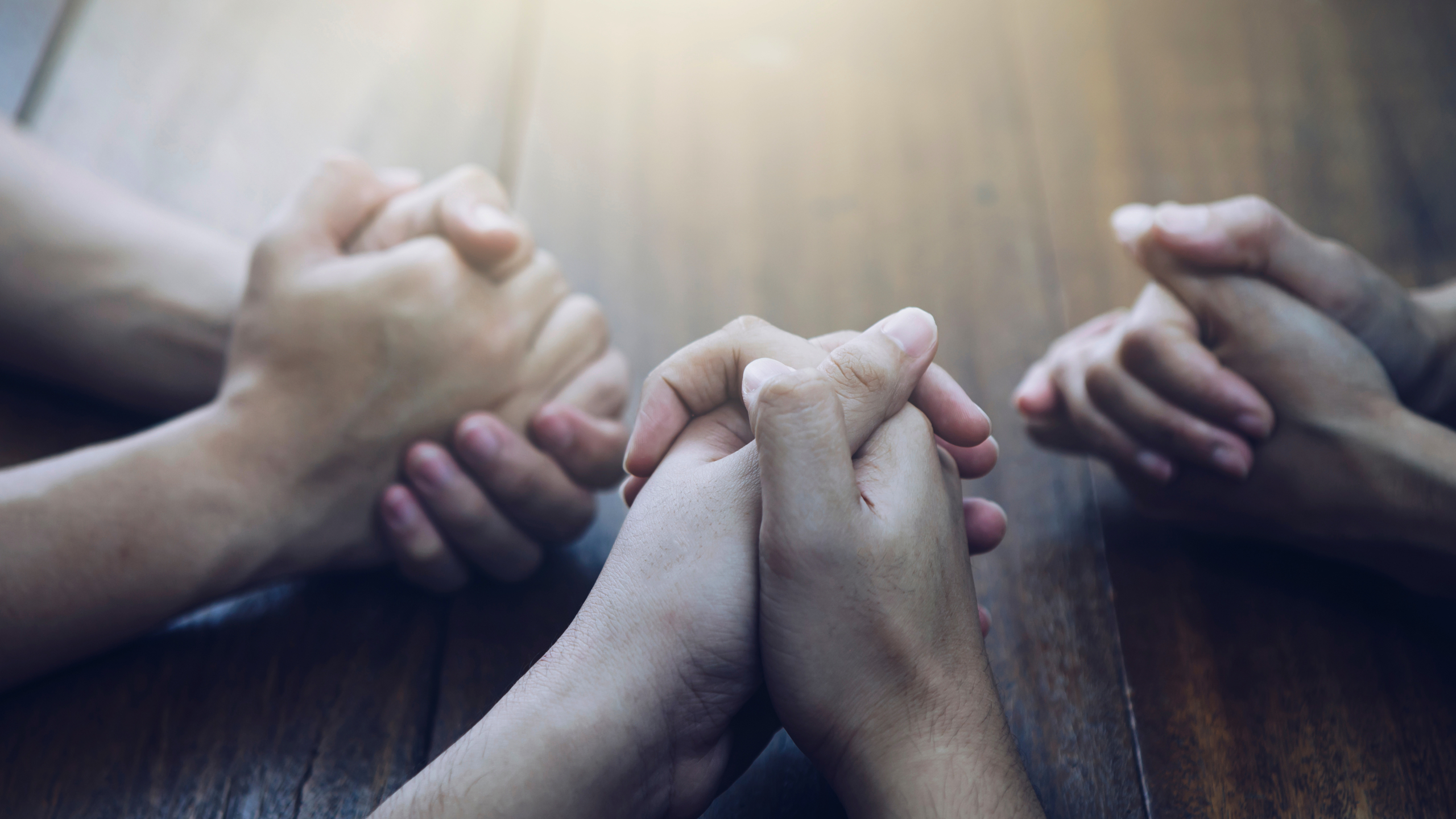 Christian bother and sister and praying together around wooden t